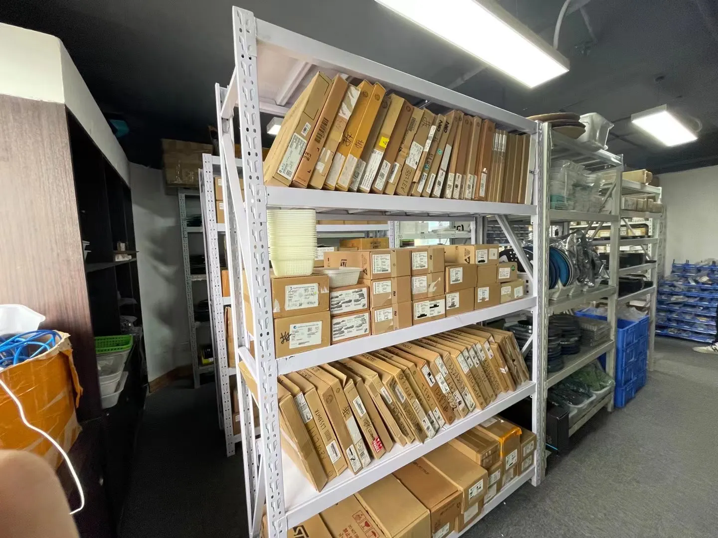 Shelving with boxed and reeled electronic components in the XINJIEDA stock room